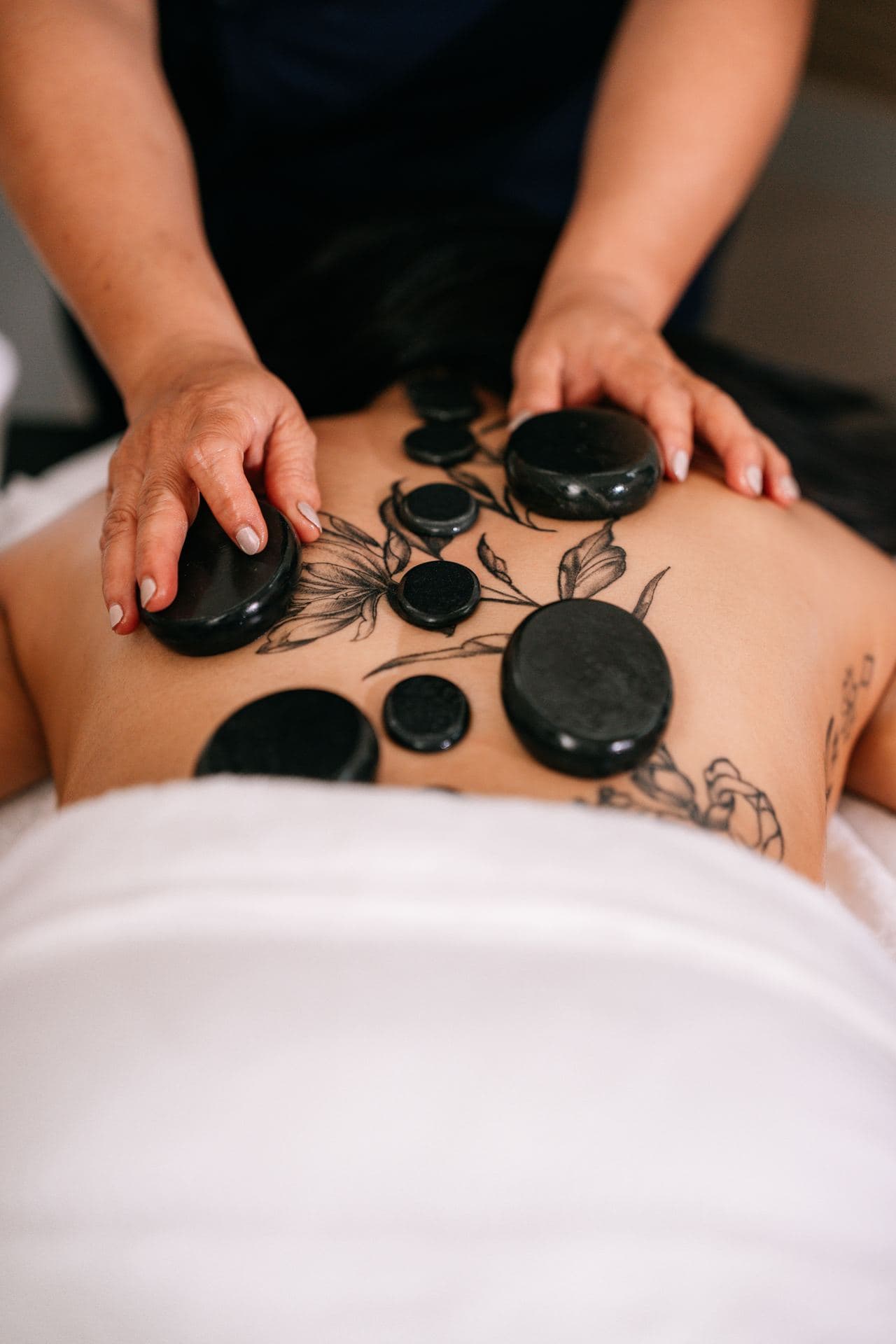 Hot stone massage arranged along a guest's back